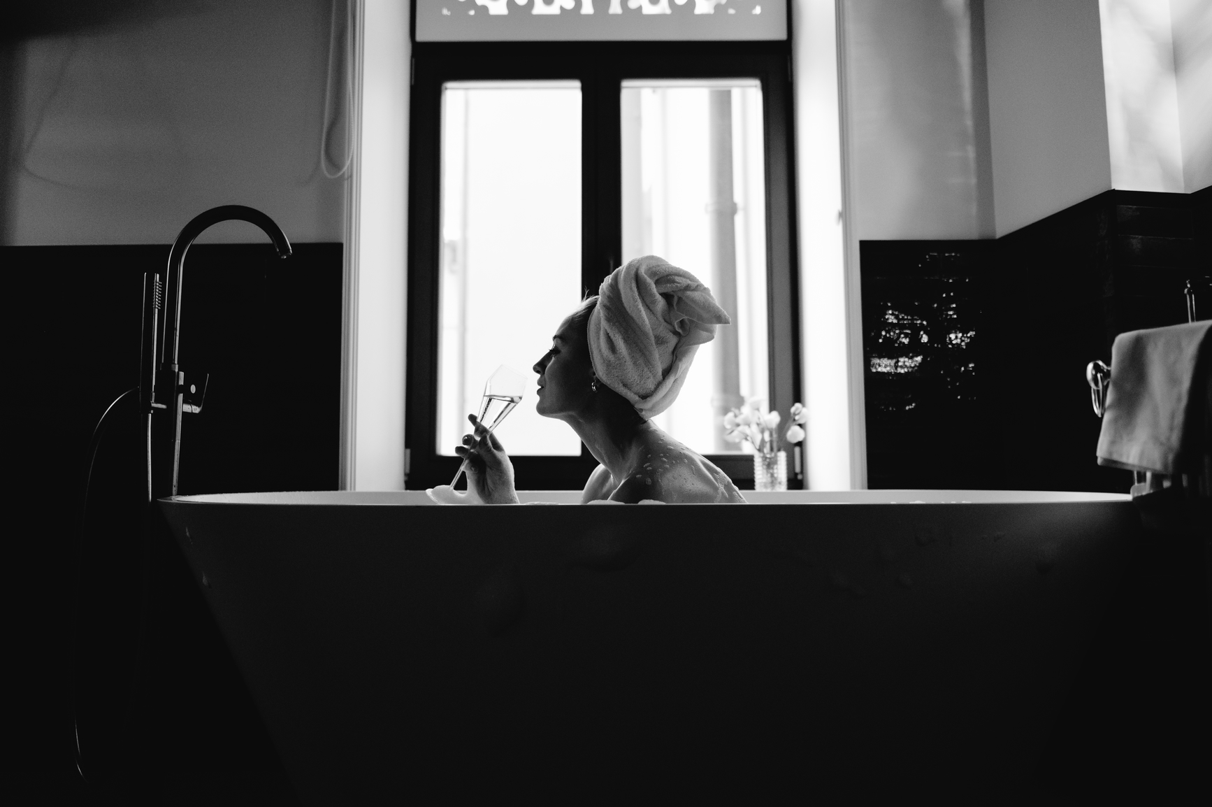 Woman in tub enjoying champagne at a luxury vacation home near Michigan