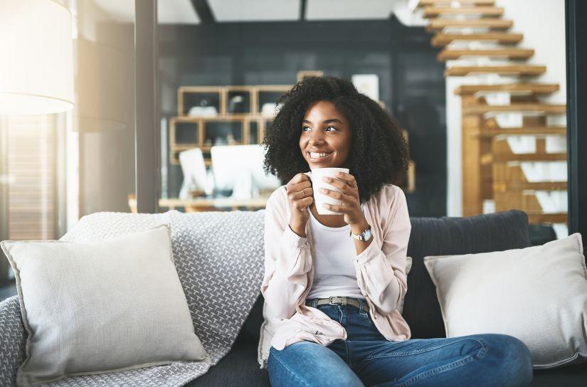 Woman sitting on sofa in her Juniper Holiday + Home vacation rental home